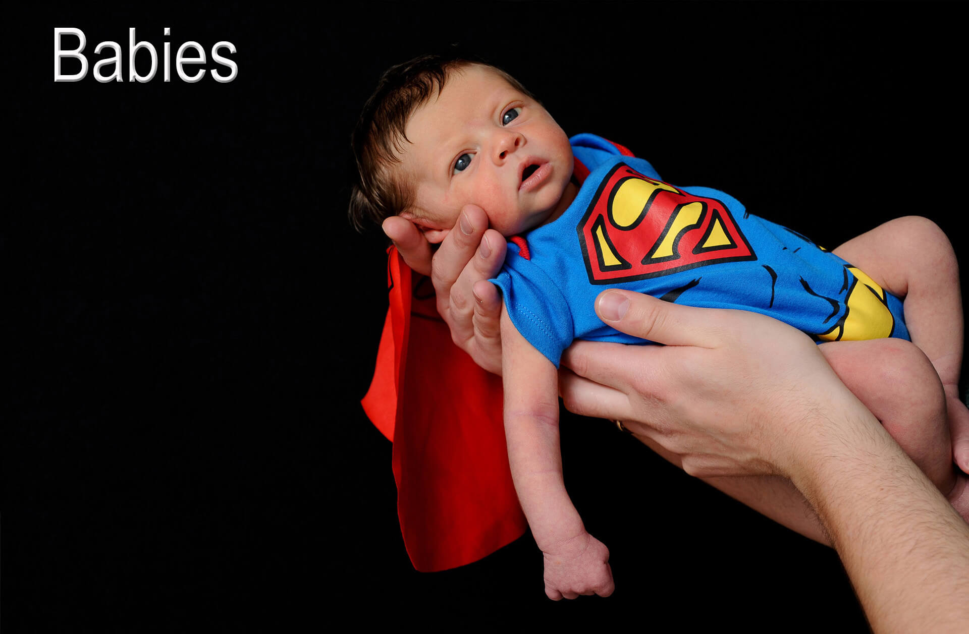 A super baby was born in the metro Detroit, Michigan area as this babe poses at the Troy studio in his Superman baby outfit.