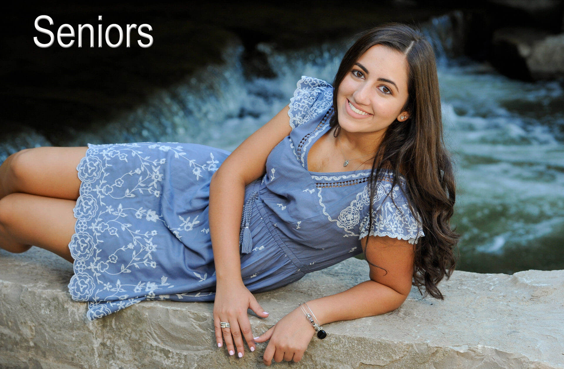 A Troy, Michigan senior poses along the bank of a river in Rochester, Michigan for her high school senior session.