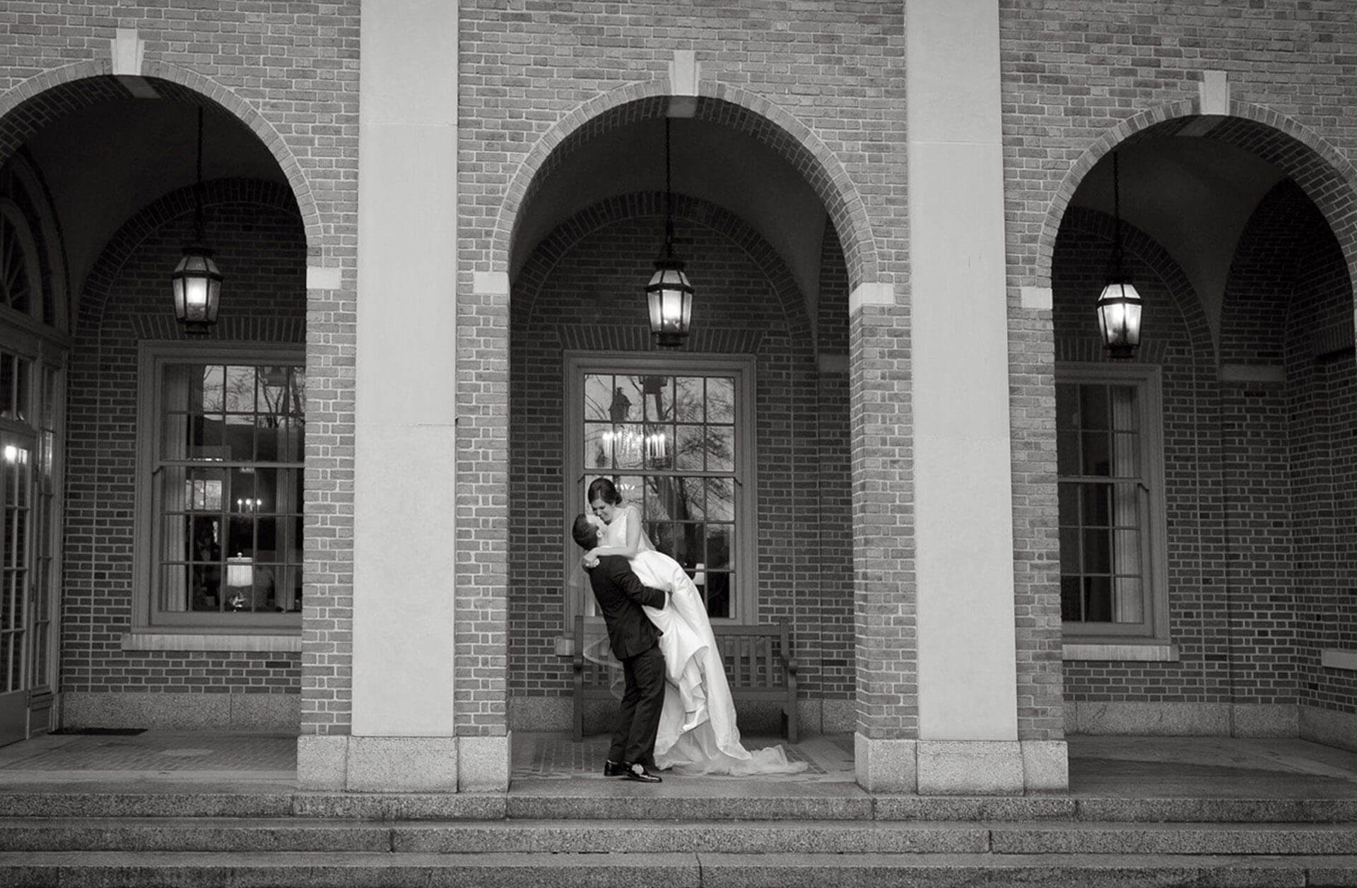 The bride and groom kiss in front of the Dearborn Inn in Detroit, Michigan.