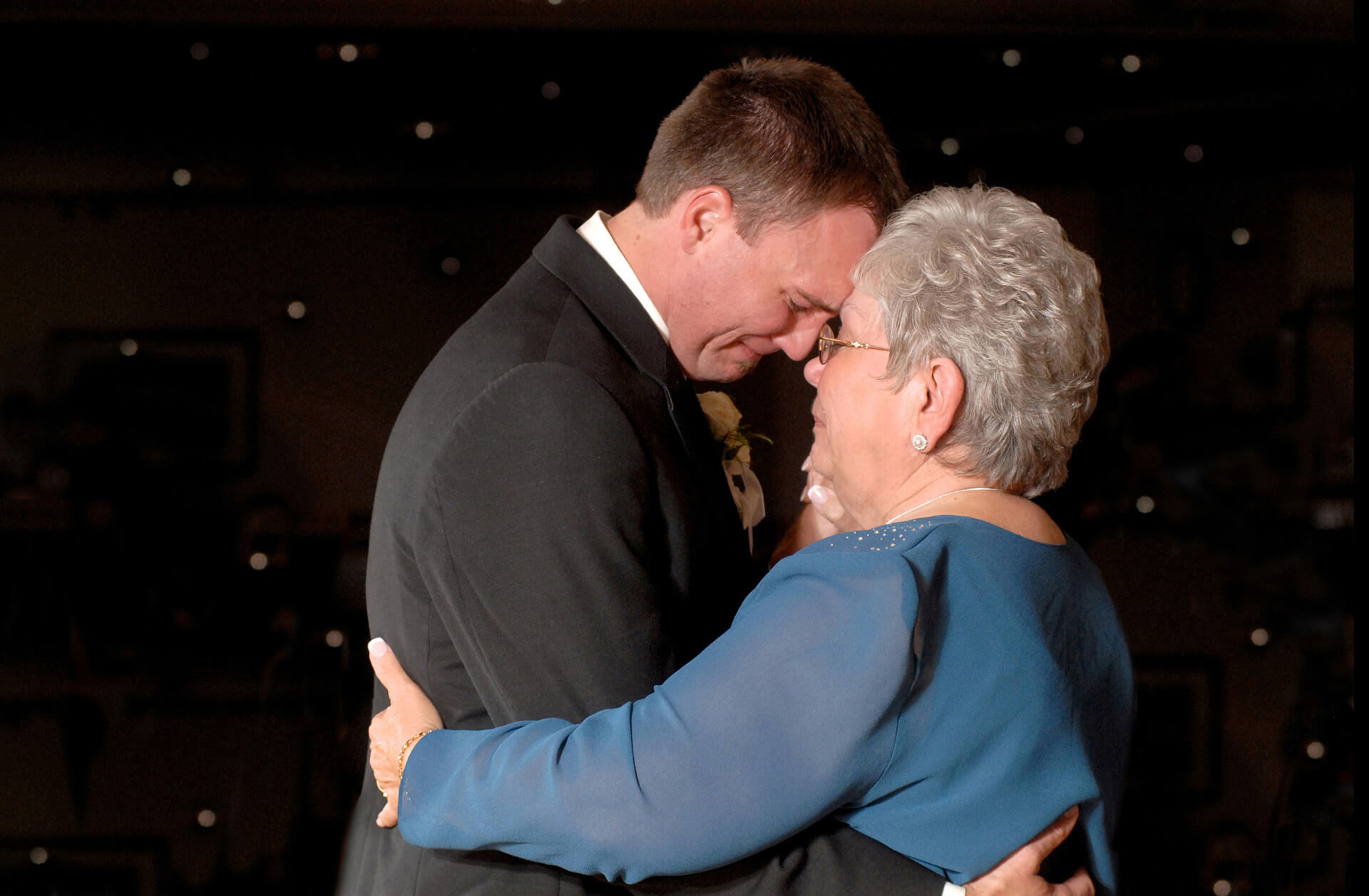 A Lake Orion, Michigan groom cries as he dances with his mother at his wedding as captured by one of the most affordable Michigan wedding photojournalists.