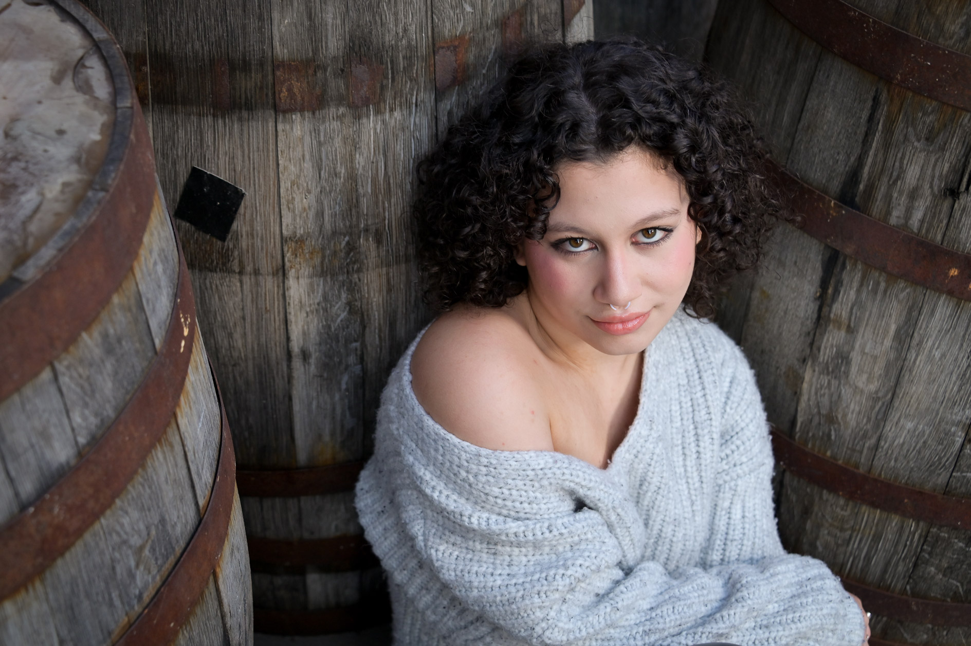 Birmingham senior posing in amongst found barrels in Detroit.