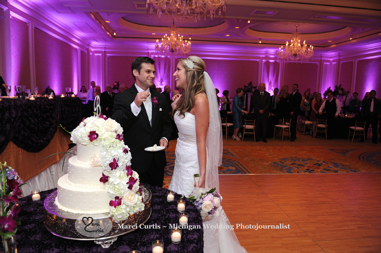 Wedding photography of a Michigan bride and groom in Dearborn, Michigan eating cake at their wedding reception at The Henry.