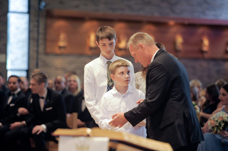 A boy helps his father prepare the host at the altar during a wedding at the St. Louise de Marillac church in Warren, Michigan. Photo by Marci Curtis