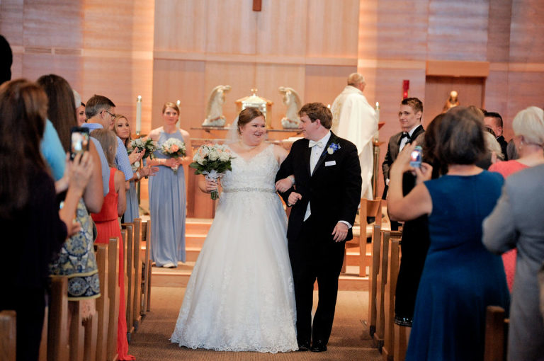 The bride and groom walk down the aisle after their wedding at the St. Louise de Marillac church in Warren, Michigan. Photo by Marci Curtis