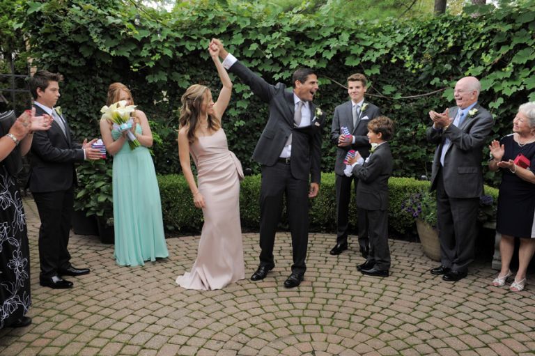 The bride and groom share a funny moment during their ceremony after a tiny second wedding at Cafe Cortina in Farmington Hills, Michigan.