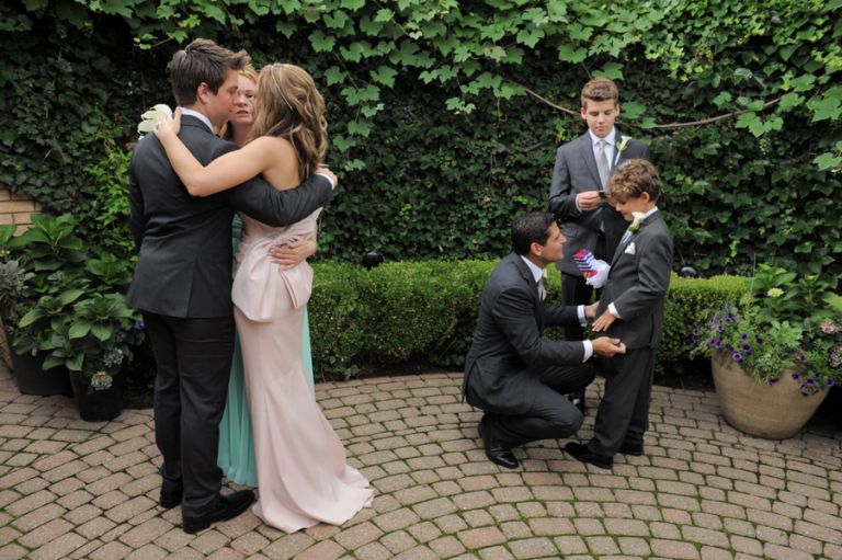 The bride and groom comfort and greet their kids after their tiny second wedding at Cafe Cortina in Farmington Hills, Michigan.