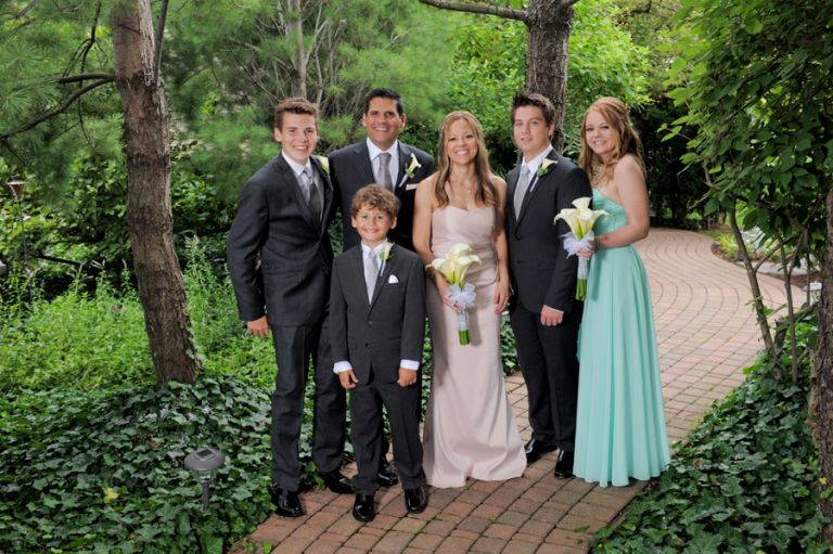The bride and groom with their blended family after their tiny second wedding at Cafe Cortina in Farmington Hills, Michigan.