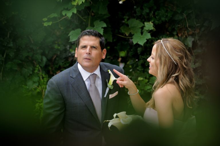 The bride and groom try to see me through a hole in the wall after their tiny second wedding at Cafe Cortina in Farmington Hills, Michigan.