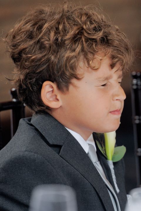 The groom's son squeezes his eyes shut during the meal after the tiny second wedding at Cafe Cortina in Farmington Hills, Michigan.