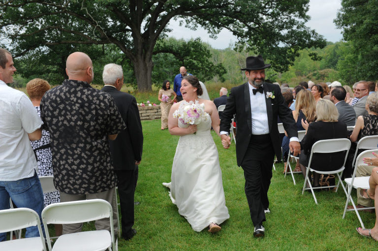 The bride greets her guests exiting the wedding ceremony site at the Indian Springs Metropark wedding in White Lake, Michigan.