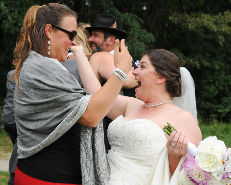The bride and groom greet their guests after wedding ceremony site at the Indian Springs Metropark wedding in White Lake, Michigan.