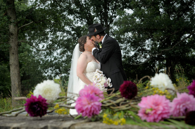 The bride and groom kiss after the wedding ceremony at the Indian Springs Metropark wedding in White Lake, Michigan.