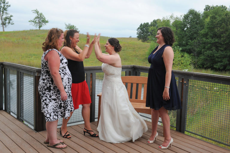 The bride high fives her friend after her wedding at the Indian Springs Metropark in White Lake, Michigan.
