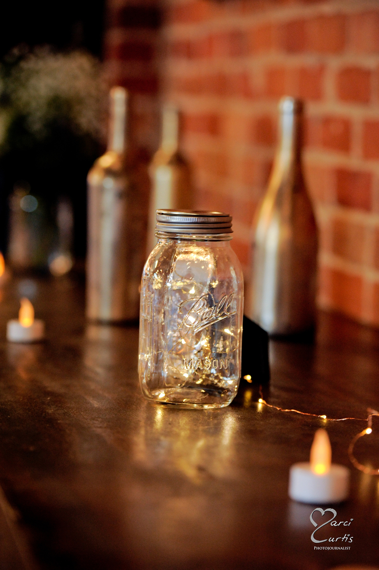 Cool jars with lights and bottle decorated the ledges surrounding the edges of the interior. Ypsilanti Freighthouse wedding photography of the newly renovated historic building in Depot Town, Ypsilanti, Michigan.