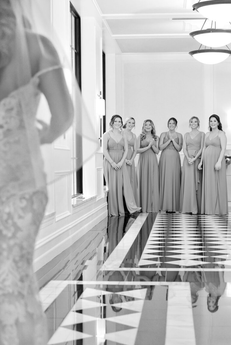 The bridesmaids react as the bride approaches for her big reveal in her dress at Shepherd's Hollow's new wedding venue in Clarkston, Michigan.
