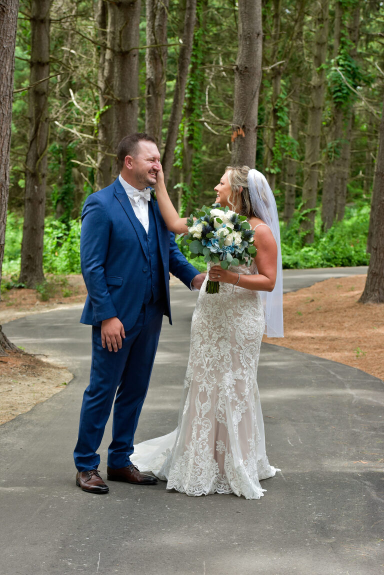 The bride wipes tears off the groom’s cheek after the first look with the bride at Shepherd's Hollow's new wedding venue in Clarkston, Michigan.