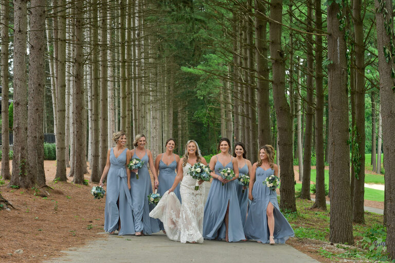 Using the dramatic lodge pole pines as a backdrop for wedding party photos of the bride and groom at Shepherd's Hollow's new wedding venue in Clarkston, Michigan.