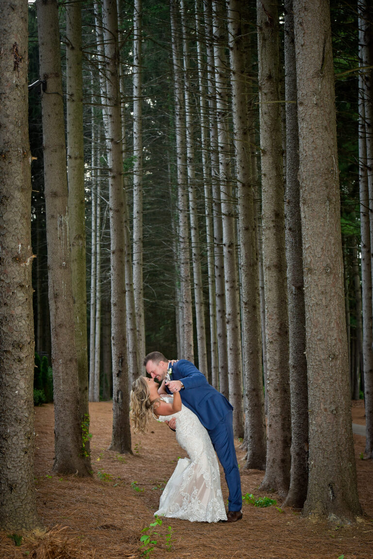 The bride and groom practice their first dance (with music!) in amongst the lodge pole pines at a wedding at Shepherd's Hollows Golf Club Clarkston, Michigan.