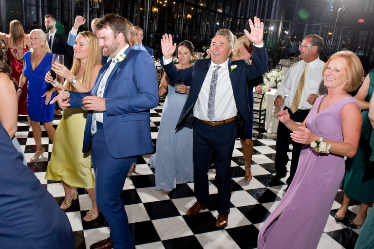 The couple’s “fans”, aka family members and wedding guests, cheer the couple on during their stage performance of “September” during their wedding at Shepherd's Hollows Golf Club Clarkston, Michigan.