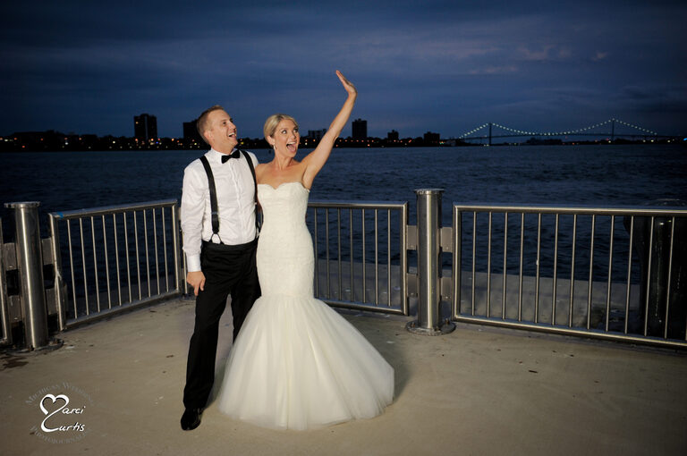 Bride waves to guests back at the Waterivew Loft wedding venue in Detroit.
