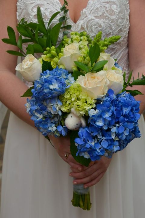 A bride tucks a mouse into her bouquet as a token of remembrance of her father.