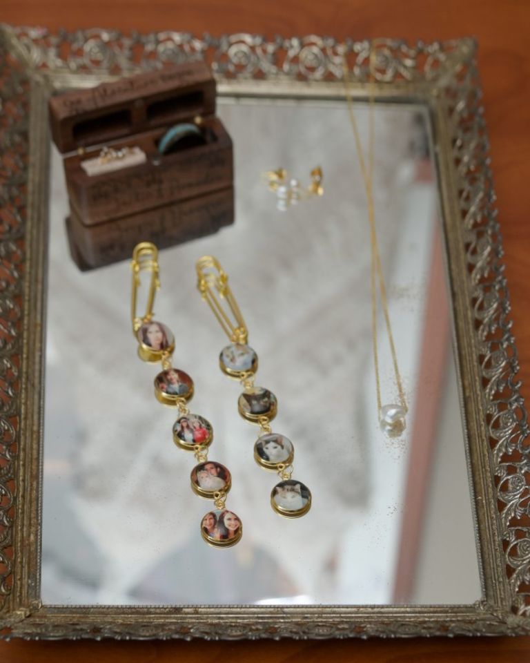 A bride pinned to strings of photos of important people to her who have died onto her bouquet before her wedding.