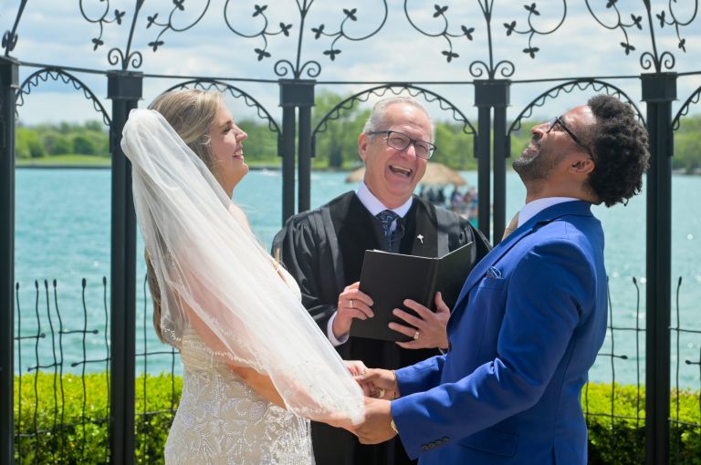 The wedding couple enjoy a laugh during their outdoor wedding ceremony at Roostertail's smaller ceremony site.