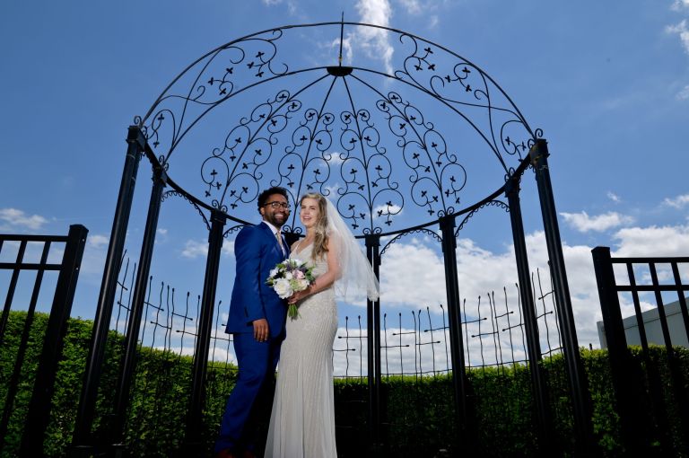 The bride and groom under the trellis at Roostertail in Detroit, Michigan.