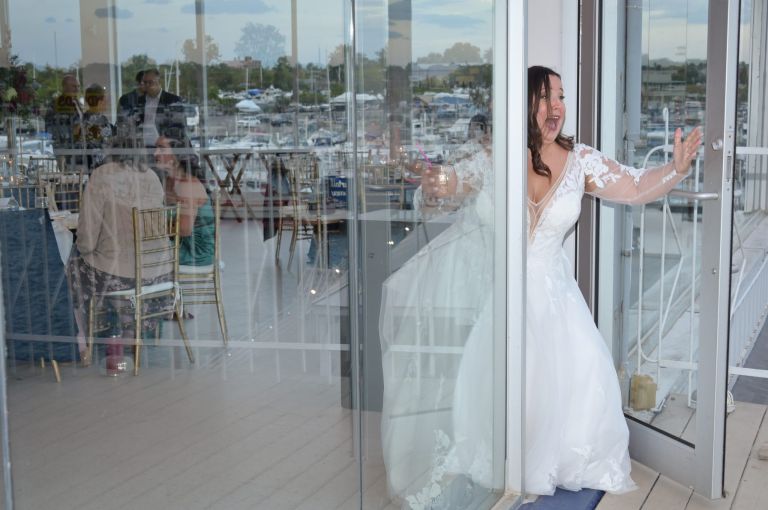 A bride searches for her husband on the deck at Roostertail in Detroit, Michigan.