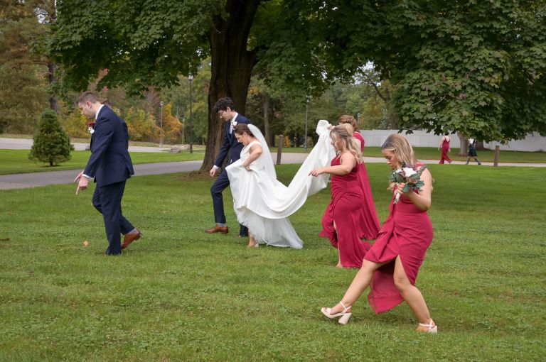 The wedding party carefully avoid goose poop a fall wedding at Addison Oaks Buhl Estates in Leonard, Michigan.