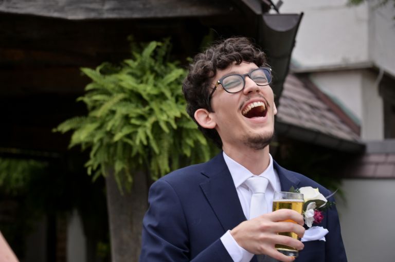 The groom enjoying himself during cocktail hour after his fall wedding at Addison Oaks Buhl Estates in Leonard, Michigan.