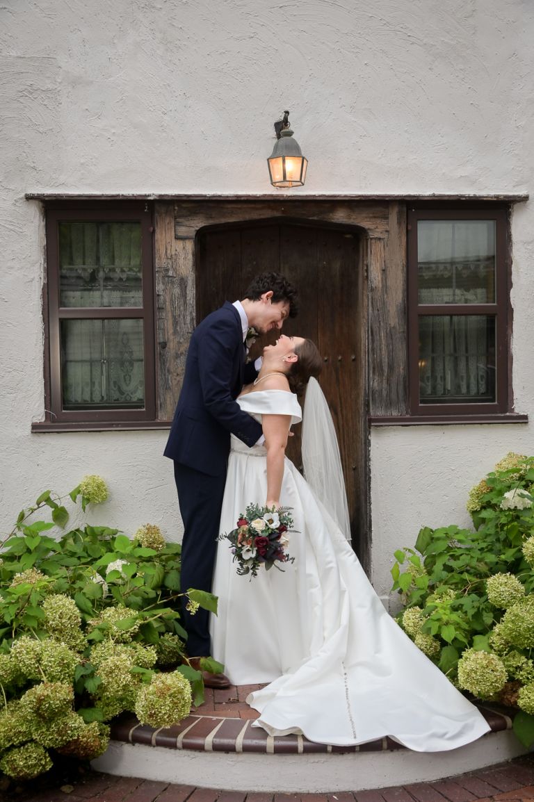 The bride and groom pose for photos during their fall wedding at Addison Oaks Buhl Estates in Leonard, Michigan.