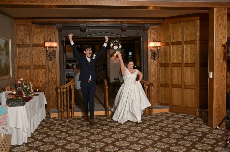 The the bride and groom's grand entrance after their wedding at Addison Oaks Buhl Estates in Leonard, Michigan.