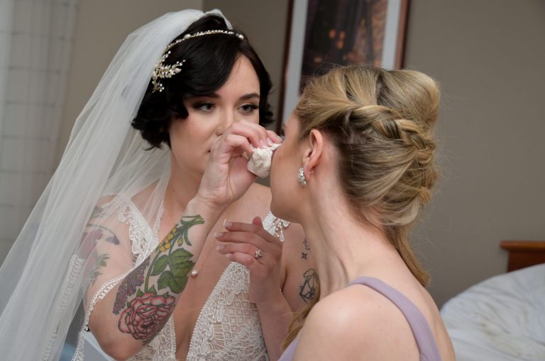 The bride's sister hugs her and cries after seeing her all dresses up for her wedding in Dearborn, Michigan.
