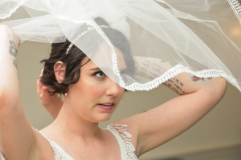 The bride adjusts her veil before walking down the aisle at the Martha-Mary Chapel in Greenfield Village, Dearborn, Michigan.
