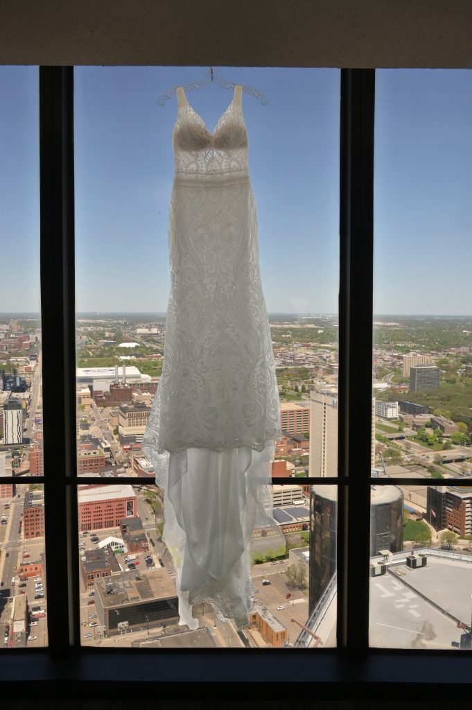 Wedding dress hanging with Detroit skyline in background.