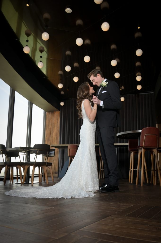 The bride and groom smooching and dancing at the bar at the Highlands Detroit.