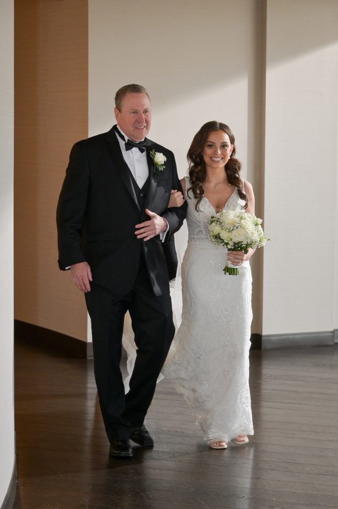 Father of the groom walks the bride down the aisle.