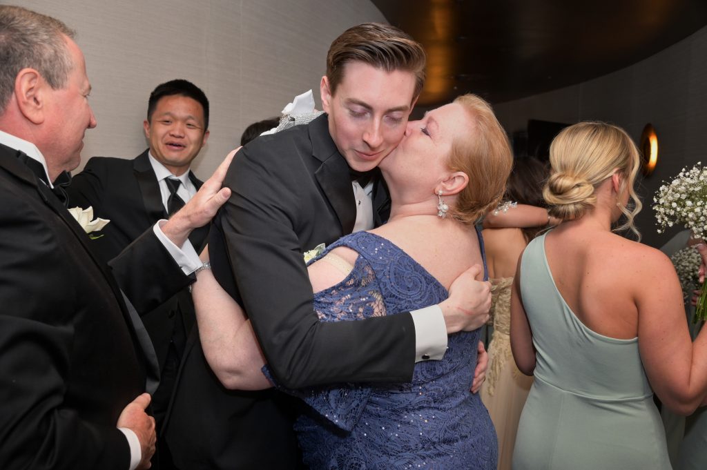 The groom's mother hugs him after the wedding ceremony.