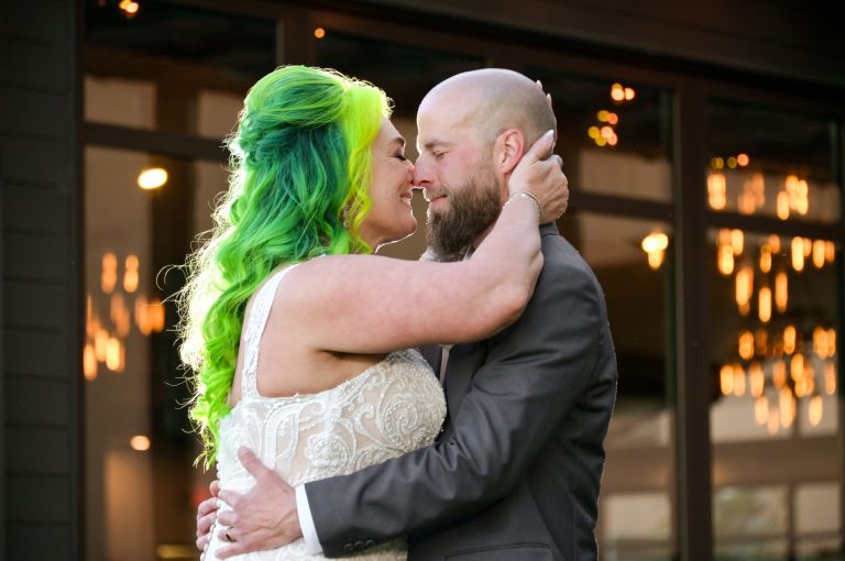 The bride and groom smooching outside their wedding venue at Eagle Crest at the Marriott in Ann Arbor/Ypsilanti.