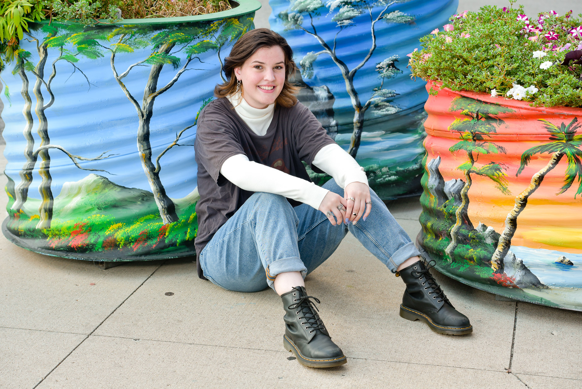 Senior sits with colorful planters downtown Detroit, MI,
