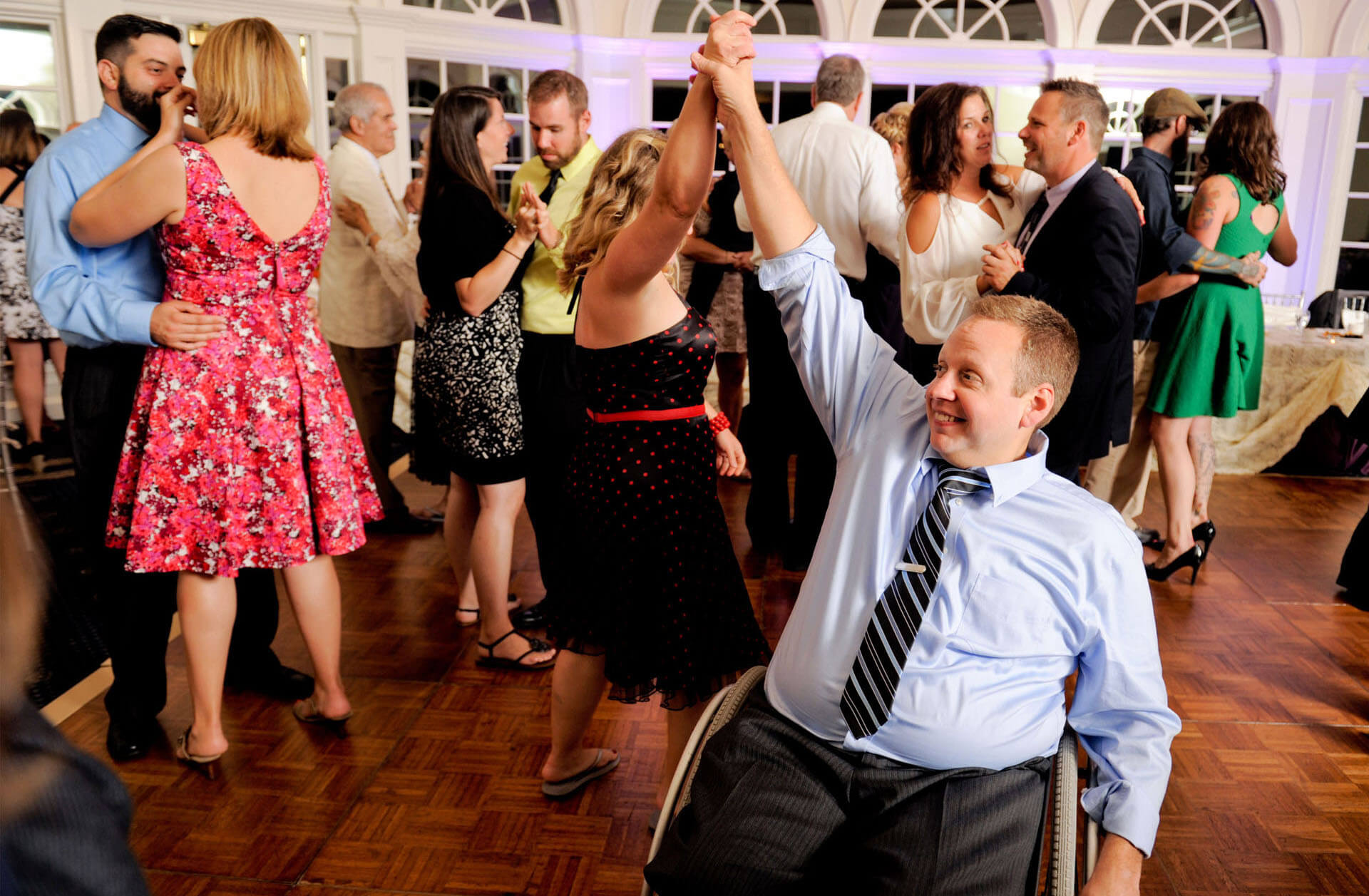 A couple dance on the tight dance floor at Cherry Creek in Shelby Charter Township, Michigan and manage to dance at the wedding reception easily navigating the guest's wheelchair.