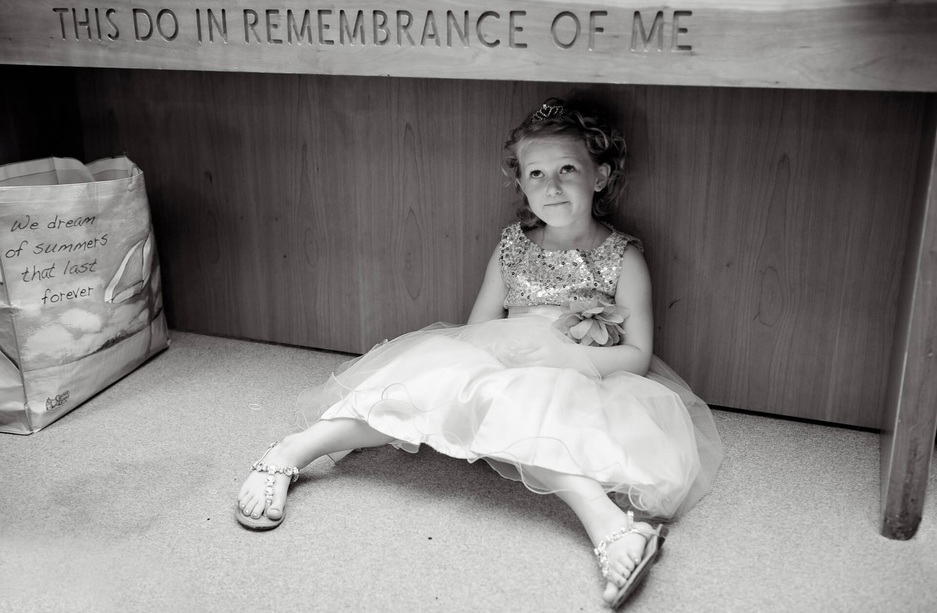 A flower girl hides under the altar while the Michigan bride gets ready during this Washtenaw County Michigan wedding.