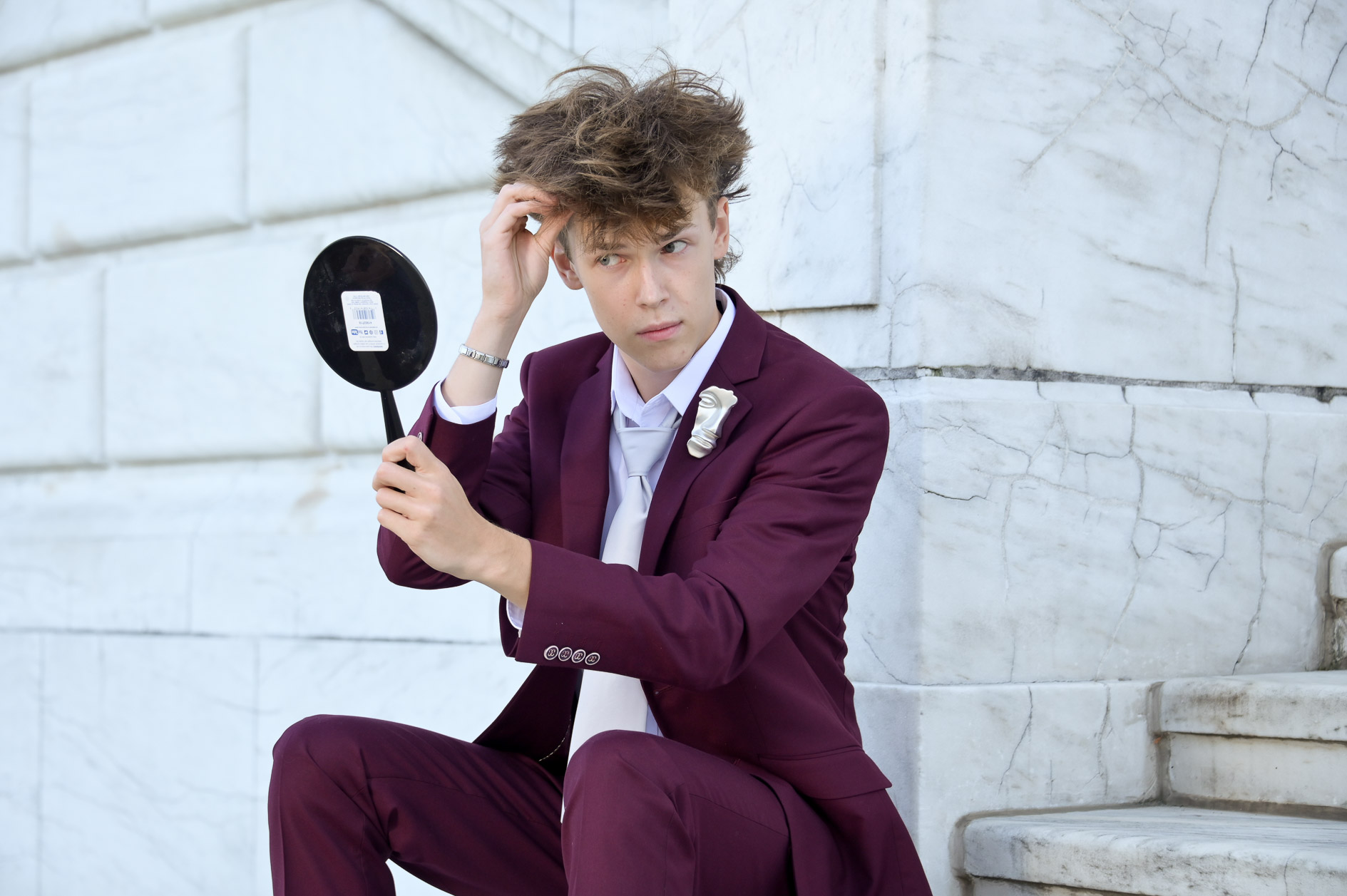 Royal Oak Michigan senior boy, Adam checking his awesome hair in a mirror during his senior picture session..