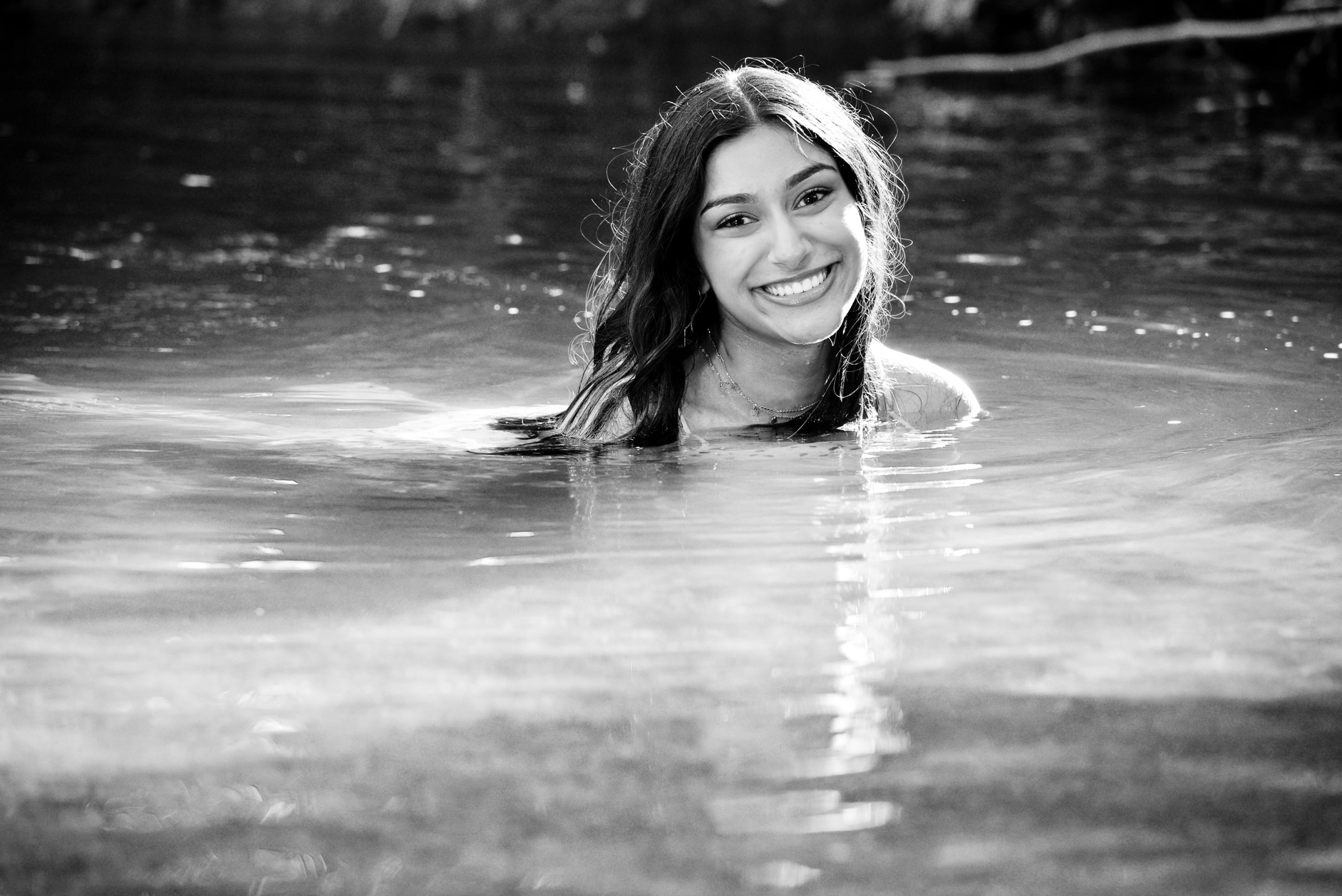 Rochester High swimmer senior submerges herself in water near Rochester, Michigan for these cool swimmer senior photos. 