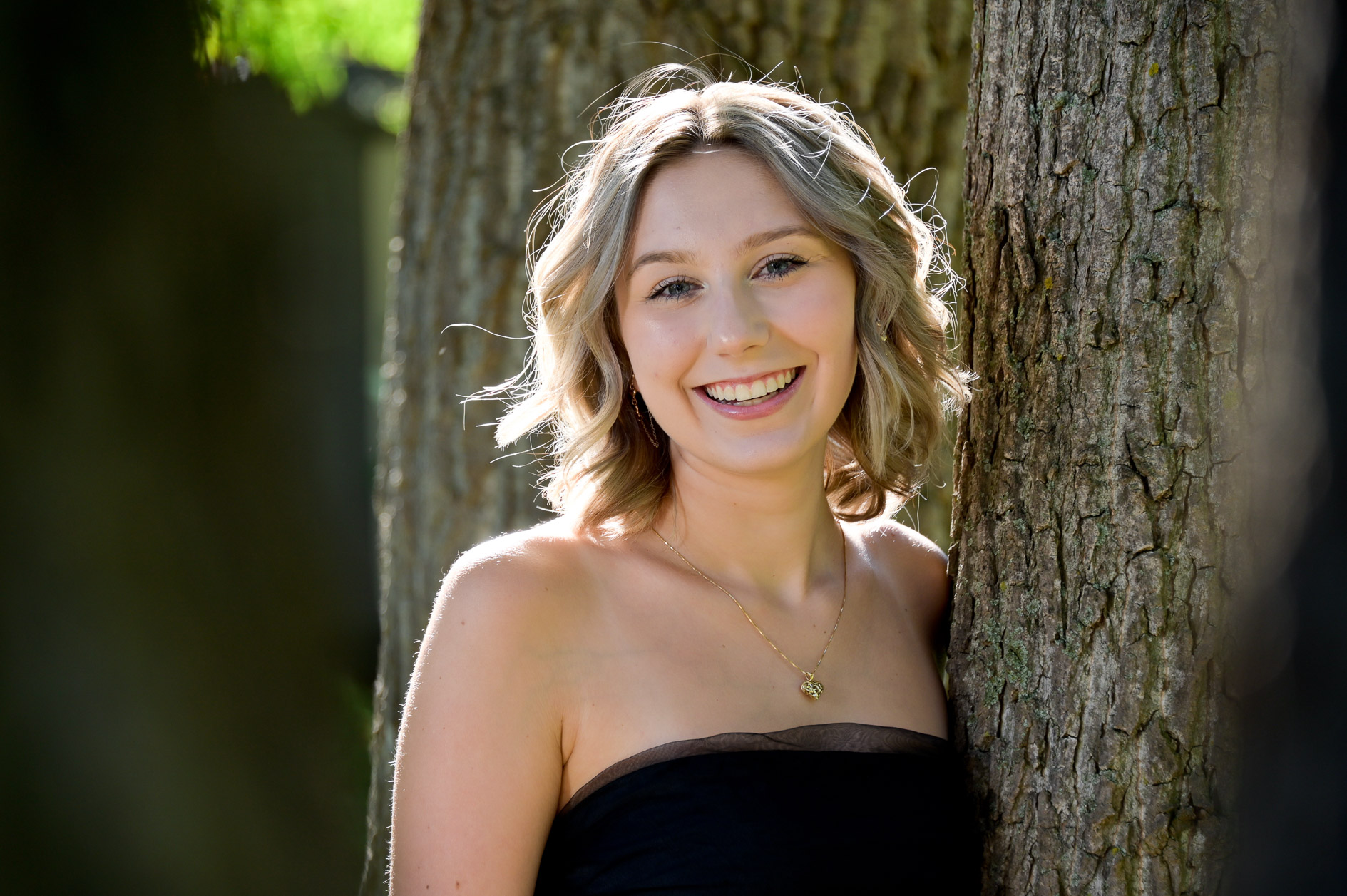 Troy senior photo taken in trees near Troy, MI.