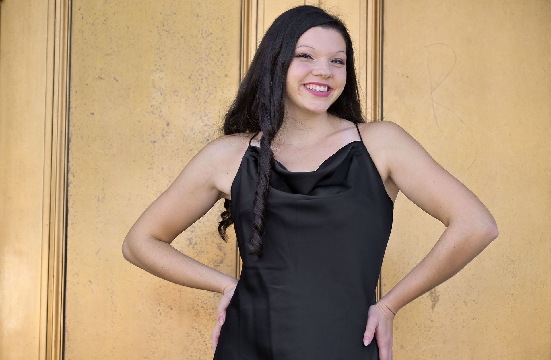 Troy High school senior Olivia posing in front of gold doors downtown Detroit.